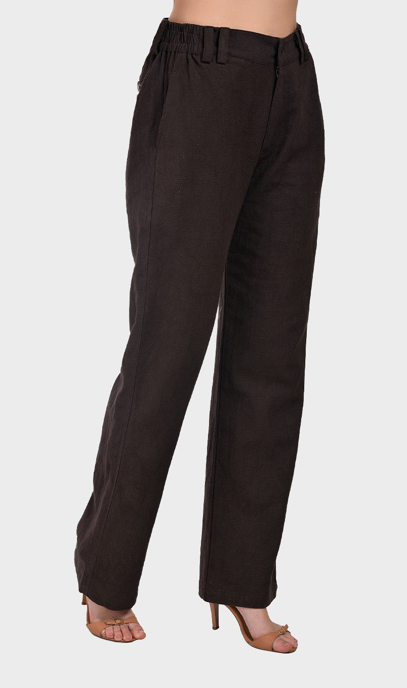 Three-quarter angle view of a model wearing relaxed-fit dark brown slub fabric tailored pants with heels.