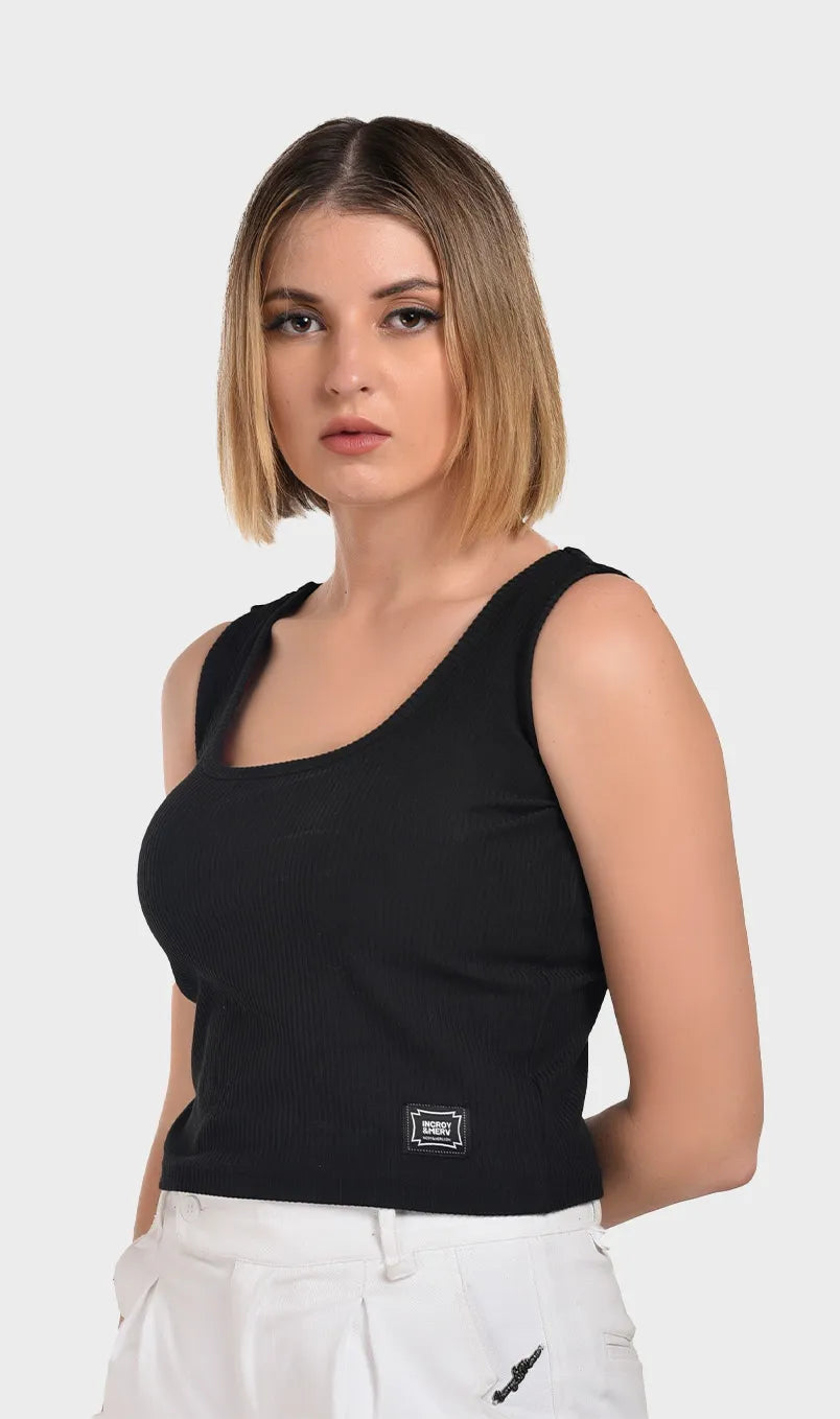 Side view of a fitted women's black ribbed tank top featuring a subtle bottom logo patch.