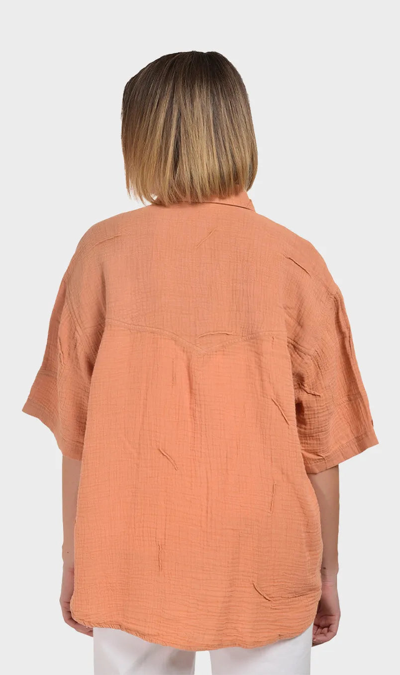 Direct back view showing the relaxed drape, back yoke, and crinkled texture of a women's 100% cotton double cloth shirt.