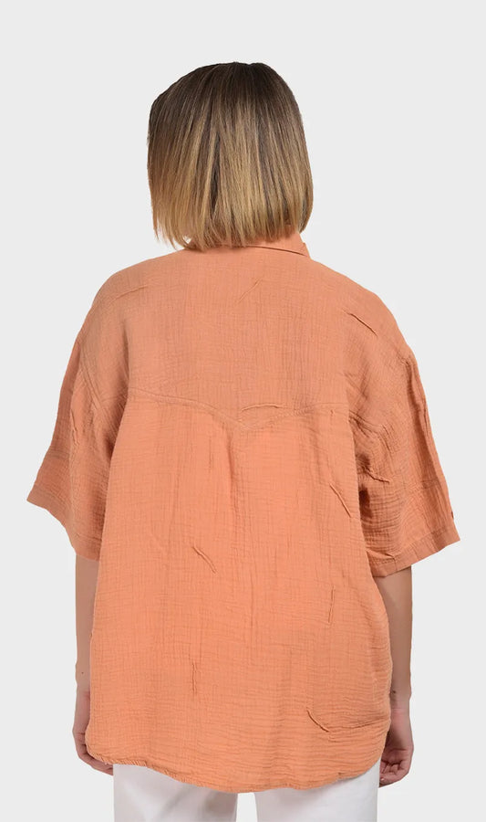 Direct back view showing the relaxed drape, back yoke, and crinkled texture of a women's 100% cotton double cloth shirt.