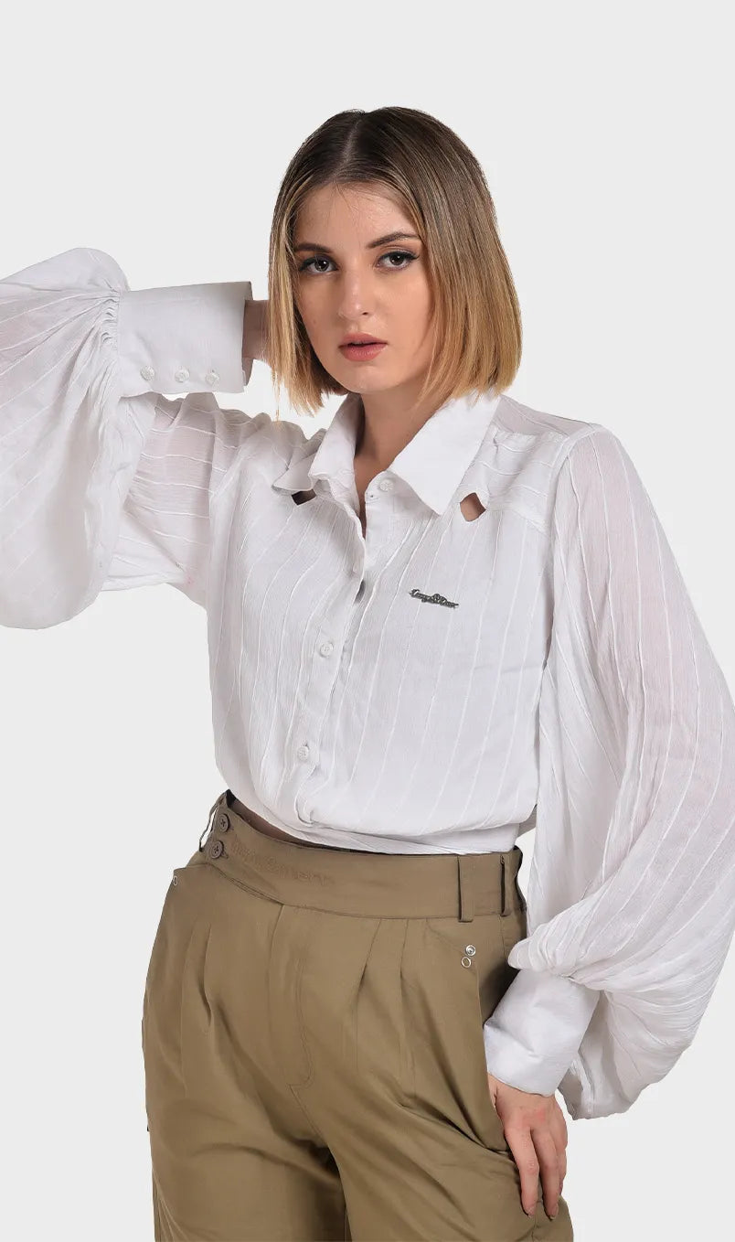 Close-up shot of a white lightweight rayon shirt showing collar cutouts, structured white cuffs, and dramatic bishop sleeves.