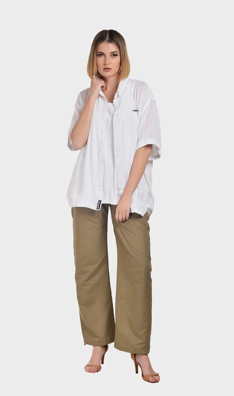 Full-body shot of a model wearing a white rayon crepe short-sleeve shirt styled with high-waisted khaki wide-leg trousers.