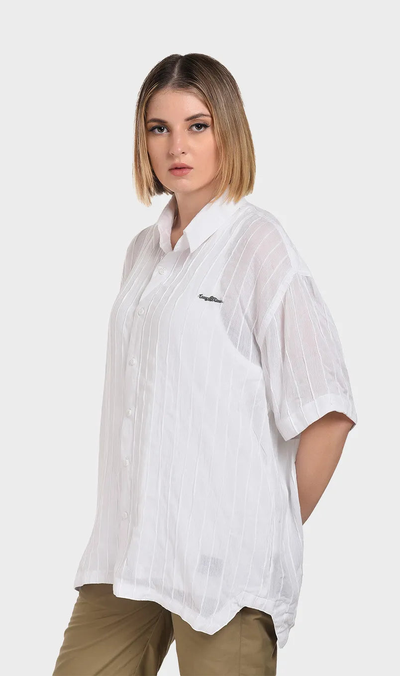 Three-quarter front view of a model wearing a relaxed-fit white short-sleeve shirt in lightweight rayon crepe.