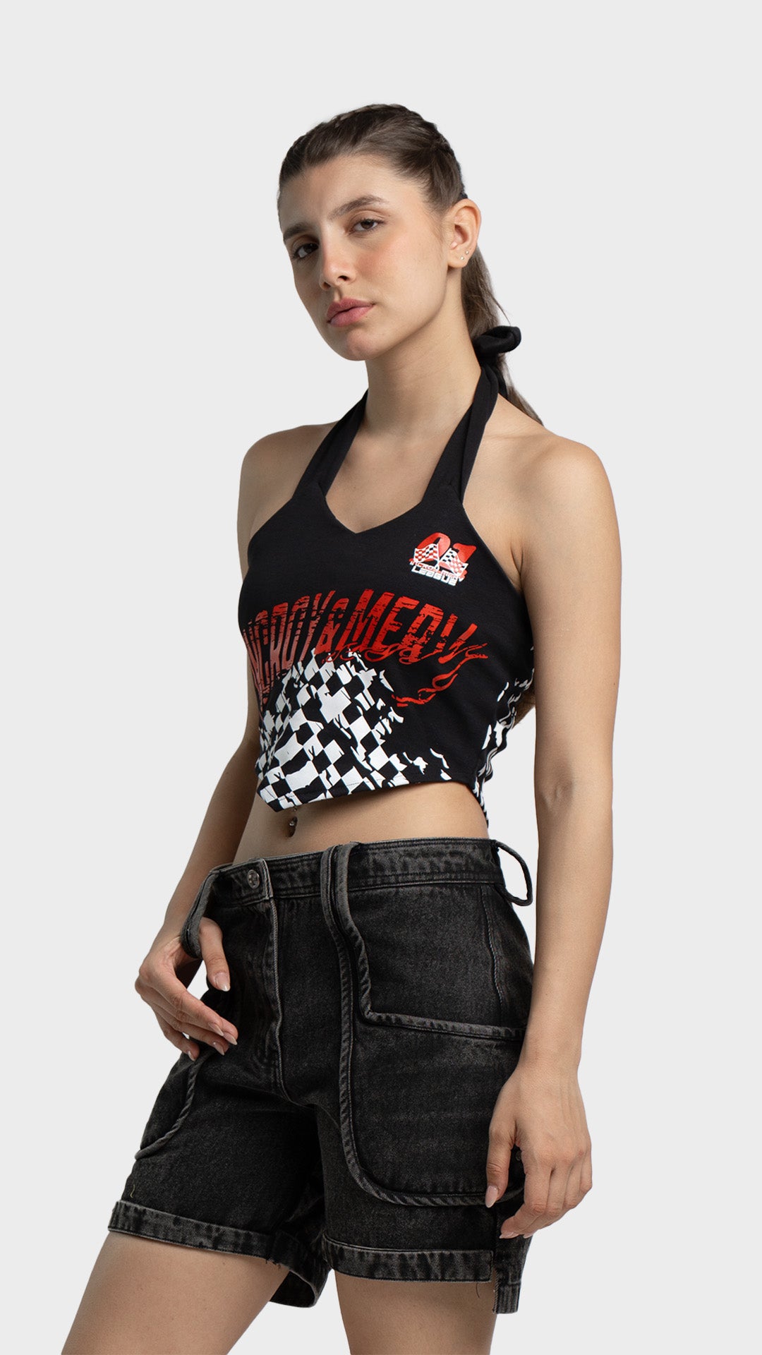 Women's racing graphic halter crop top with black denim cargo shorts outfit.