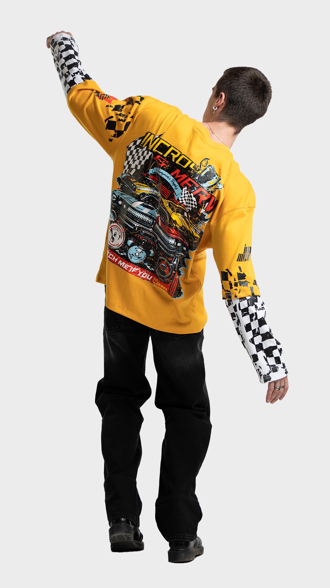 Yellow double sleeve racing tee outfit. Full back dynamic view of Incroy & Merv oversized long sleeve summer streetwear top styled with dark loose pants.